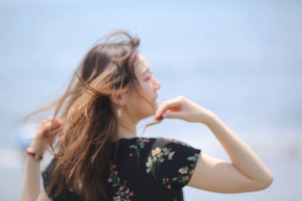 istock Young woman relaxing on windy beach 970232862