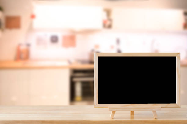 istock Blank chalkboard on wood table with copy space for your text message or product display in uxury restaurants in the mall blur background. 970232922
