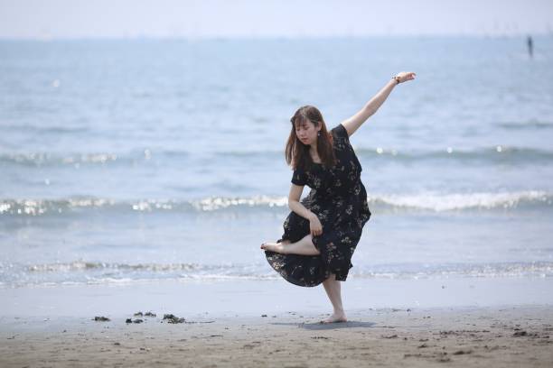 istock Young woman dancing on wet sandy beach 970233620