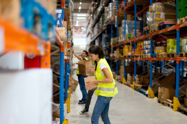 lagerarbeiter sind waren auf den regalen stapeln. - warehouse worker stock-fotos und bilder