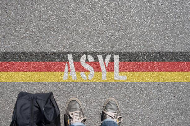istock A man with a suitcase stands in front of the German border and is looking for asylum 970240840