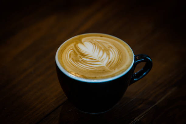 istock Coffee cup with latte art on wooden background . Selective focus 970240972