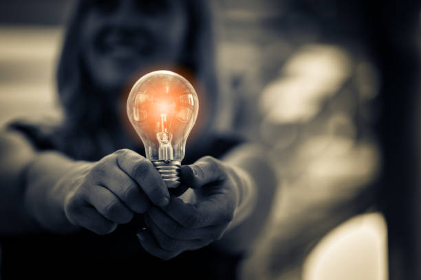 女性手保持電球創造アイデア コンセプト - illusion efficiency light bulb energy ストックフォトと画像