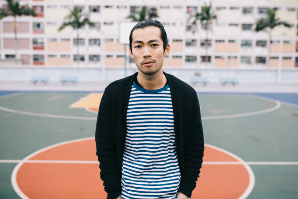 istock Young asian guy standing on a basketball court. 970253546