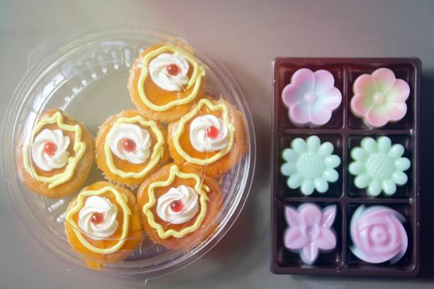 Confectionery, sweets, sweets. chocolate cupcakes, muffin cupcakes decorated with a white flower on a white background. foodphoto isolate