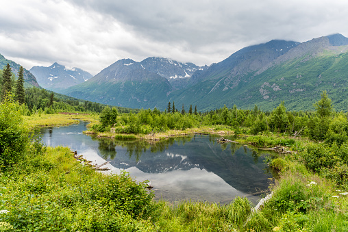 The mountains around the calm waters of Alaska's Eagle River are reflected.