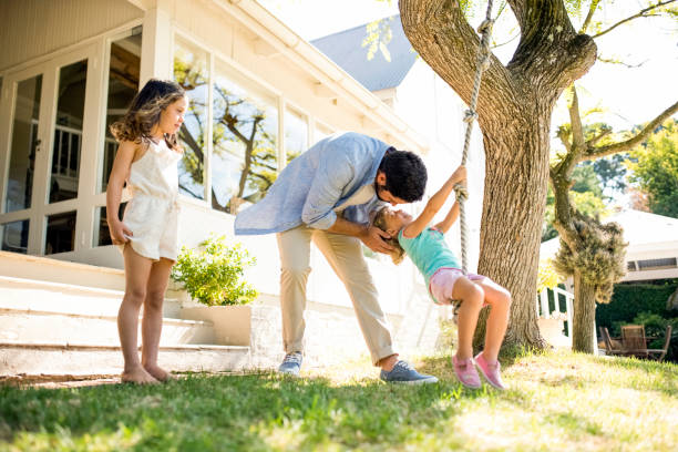 istock Playful father with daughters in yard 970267054