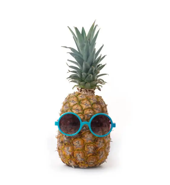A pineapple in a dark mirror on a white background