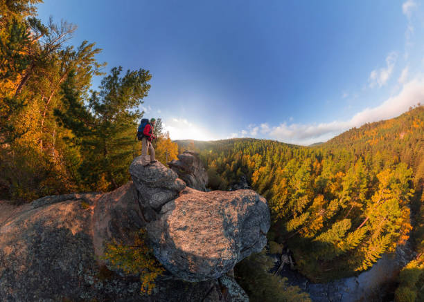 istock Backpacker on top of a rock fall at dawn. Wide angle aerial panorama 970271170