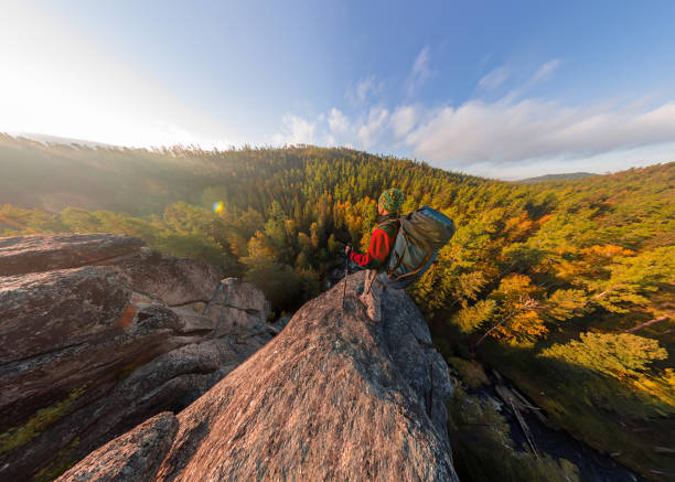 istock Backpacker on top of a rock fall at dawn. Wide angle aerial panorama 970271682