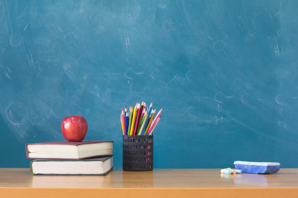 istock Apple puts on a book studying ,The background is blackboard, educational concepts 970272062