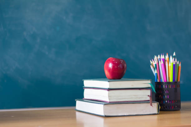 istock Apple puts on a book studying ,The background is blackboard, educational concepts 970272072