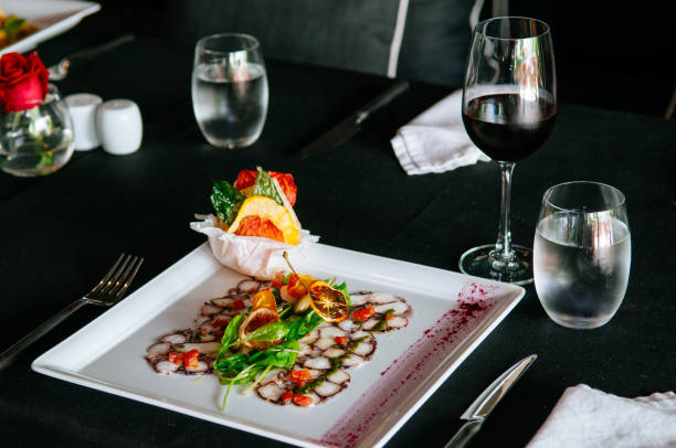 istock Fresh octopus carpacio with citrus spinach salad pesto balsamic dressing, fine dinning table setting in restaurant 970281294
