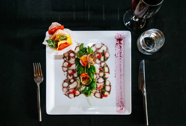 istock Fresh octopus carpacio with citrus spinach salad pesto balsamic dressing, fine dinning table setting in restaurant 970281296