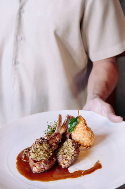istock Waiter serving grilled lamb chops with crust, gravy and deep fried potato 970281456