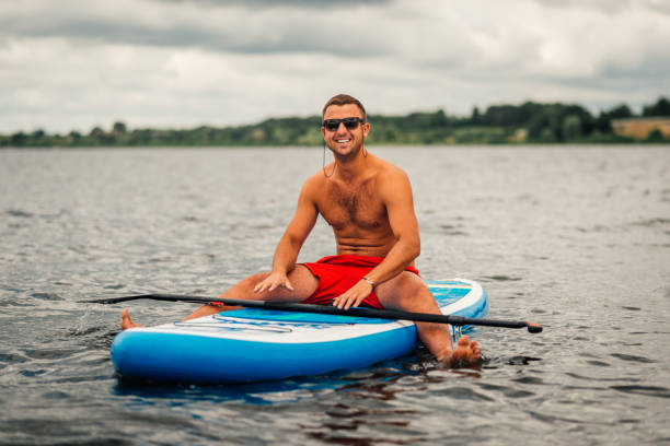 istock a man in shorts sitting relaxed on   sup surf 970288882