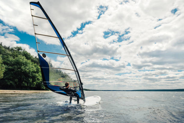 facet w waggon pływa na windsurfingu na jeziorze - windsurfing zdjęcia i obrazy z banku zdjęć