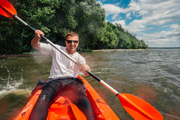 istock cheerful guy sits in   red kayak and row with a paddle 970289034
