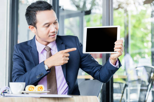 istock business asian man present  blank screen tablet for business presentation 970289148