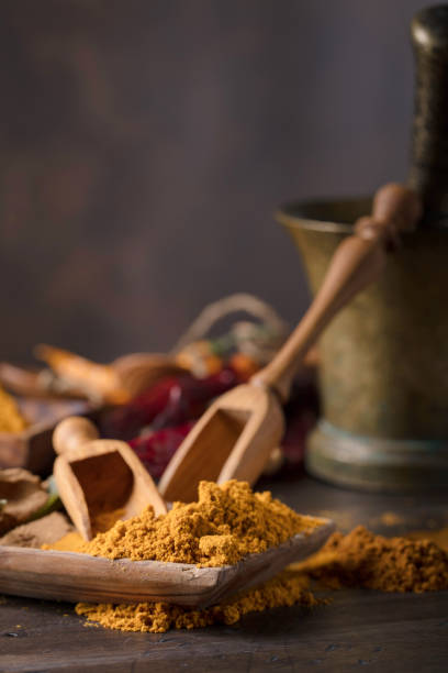 Various Indian spices with wooden spoons on a old wooden table, copy space for  your content.