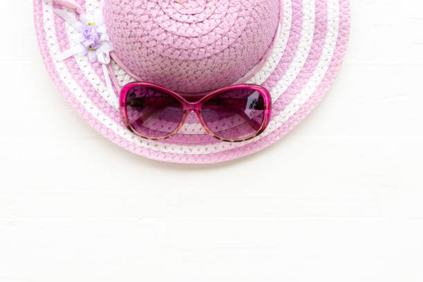 istock Beach accessories including blue sunglasses and bright pink or purple beach hat on white wooden background for summer holiday and vacation concept. 970296770