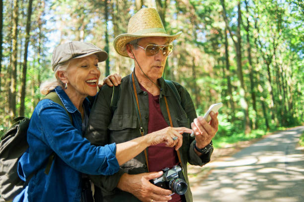 istock senior couple using phone in nature 970297394