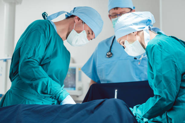 des médecins effectuant l’opération à l’hôpital - cesarean photos et images de collection