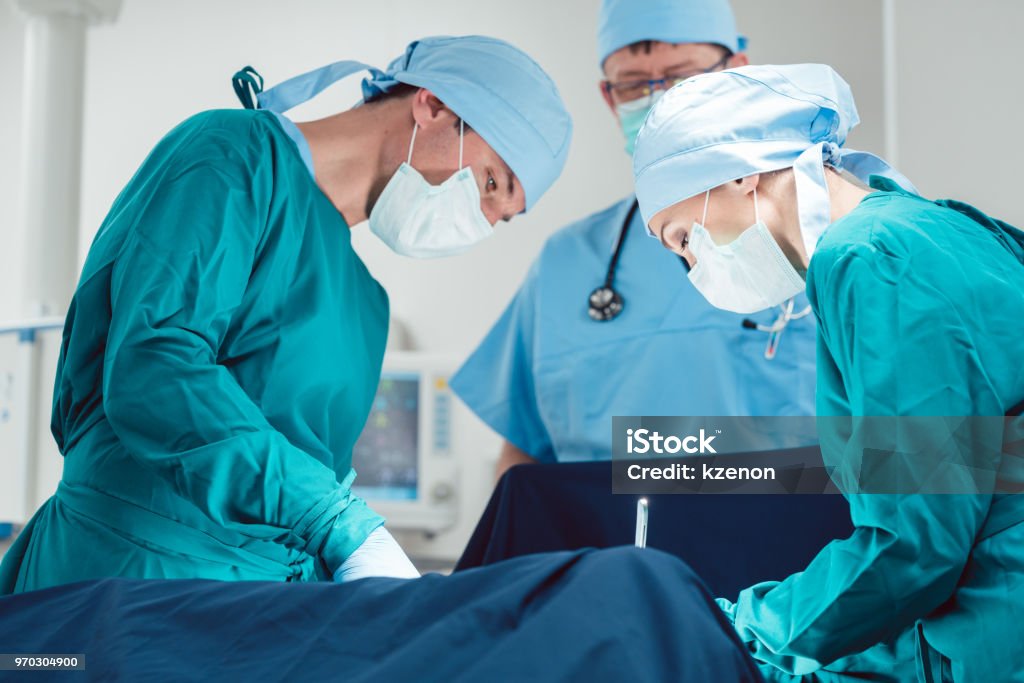 Medical doctors performing operation in hospital Medical doctors performing operation in hospital using scalpel and tools Surgery Stock Photo