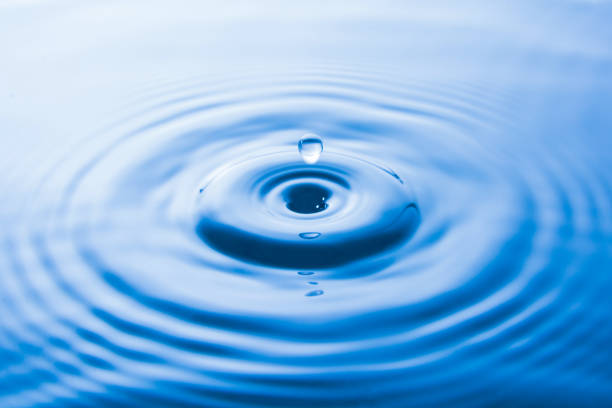 istock Water drop falling into water make waves. Water splash or water drop background. 970305238