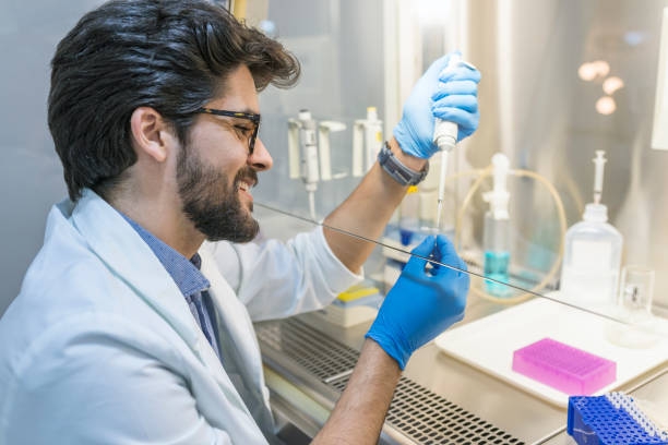 Research Scientist Uses Micropipette Filling Test Tubes in a Big Modern Laboratory He's Conducts Experiments in Modern Laboratory. Research Scientist Uses Micropipette Filling Test Tubes in a Big Modern Laboratory. Working in the fume hood fume cupboard stock pictures, royalty-free photos & images