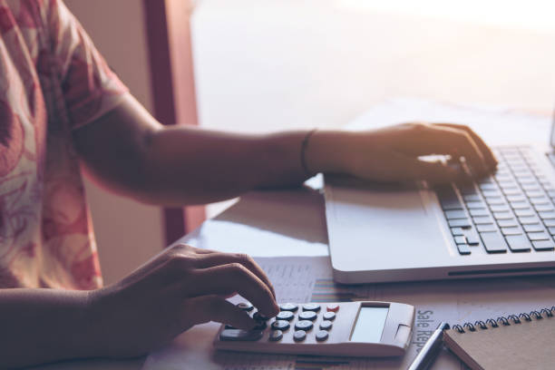 istock close up woman using calculator and laptop on paper graph data with doing finance at office. 970308362