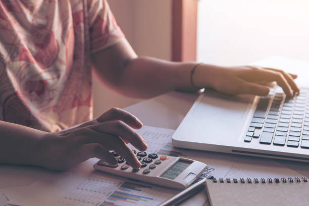 istock close up woman using calculator and laptop on paper graph data with doing finance at office. 970309164