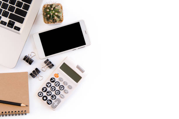istock White office desk table, workspace office with laptop, smartphone black screen, pen, calculator, glasses, Top view with copy space 970318334