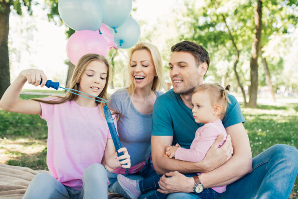 istock Young family looking at daughter using bubble wand and soap sud 970319144