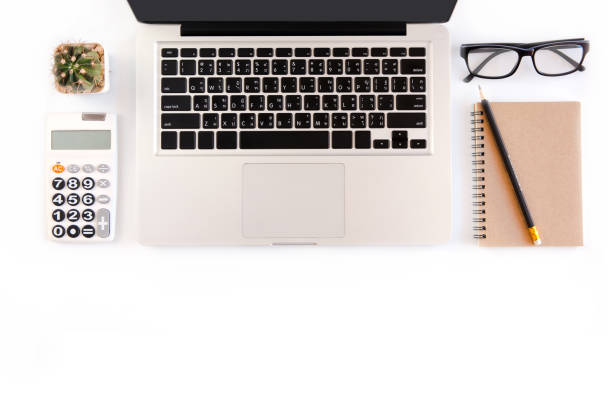 istock White office desk table, workspace office with laptop, smartphone black screen, pen, calculator, glasses, Top view with copy space 970319190