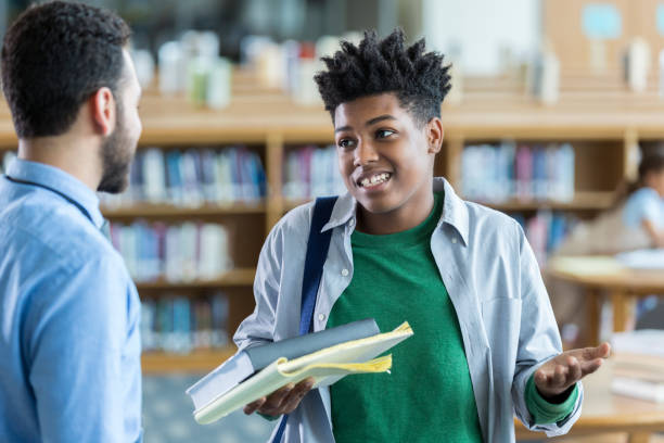 istock Male high school student stands with teacher and shrugs 970320174