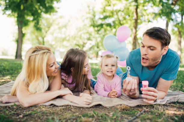 istock Happy family looking at father making bubbles with bubble wand 970322516