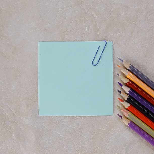 istock sheet of paper for notes and colored pencils on paper background 970371762