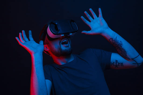 istock Shocked man in VR glasses on black 970375414
