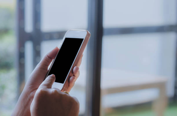 istock man holding smartphone using touching on black screen in hand. mobile phone technology concept. 970375938