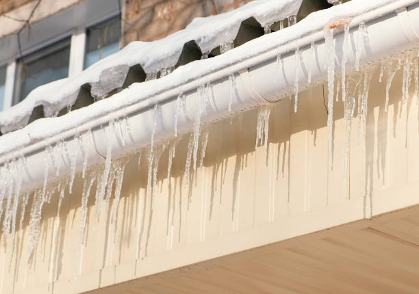 istock Icicles hang from a drainpipe of a house. 970376376
