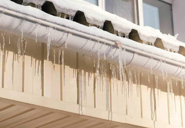 istock Icicles hang from a drainpipe of a house. 970376434