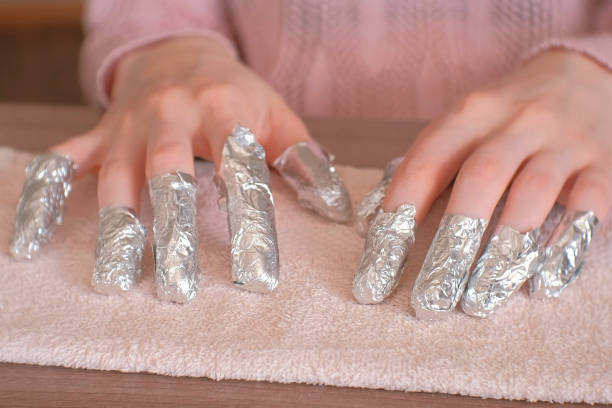 istock Removing gel Polish from nails. All fingers with foil on both hands. Close-up hand. Front view. 970380096