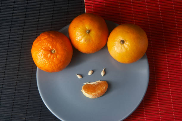 istock Tangerines in plate on black and red background 970387910