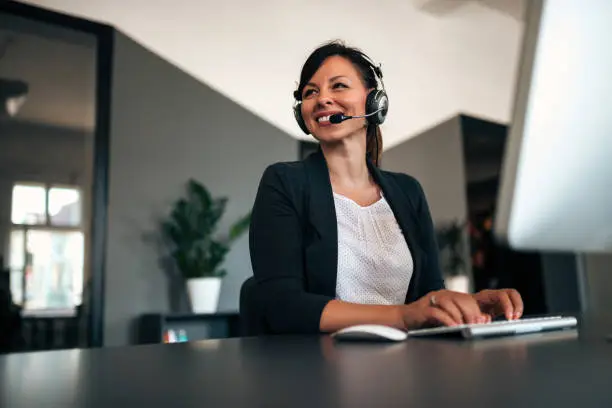 Photo of Beautiful call center consultant in headphones.