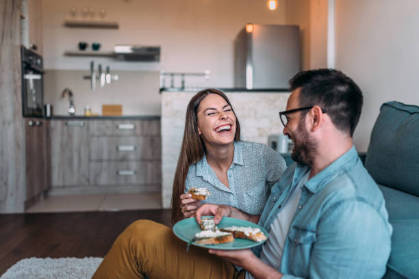istock Laughing couple eating sandwiches. Close-up. 970392034