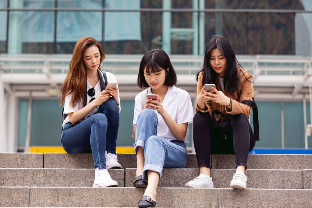 istock Women texting while waiting other friends coming 970395700