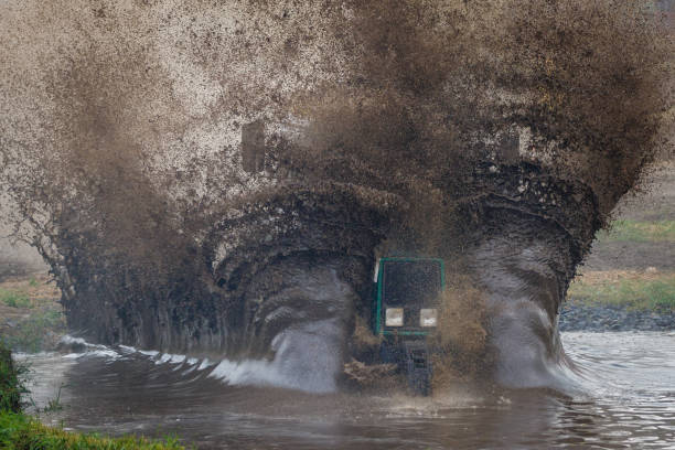 istock The tractor at high speed moves through a large deep puddle, creating a huge cloud of spray 970395806
