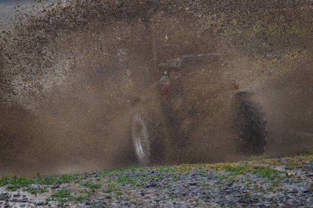 istock The tractor at high speed moves through a large deep mud, creating a large cloud of spray 970395814