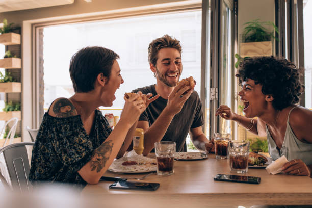 amigos pasando el rato en un restaurante - hamburguesa alimento fotografías e imágenes de stock